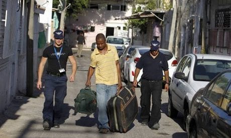 Israeli immigration officers escort an African migrant carrying luggage in south Tel Aviv June 13, 2012. (Photo: Reuters)