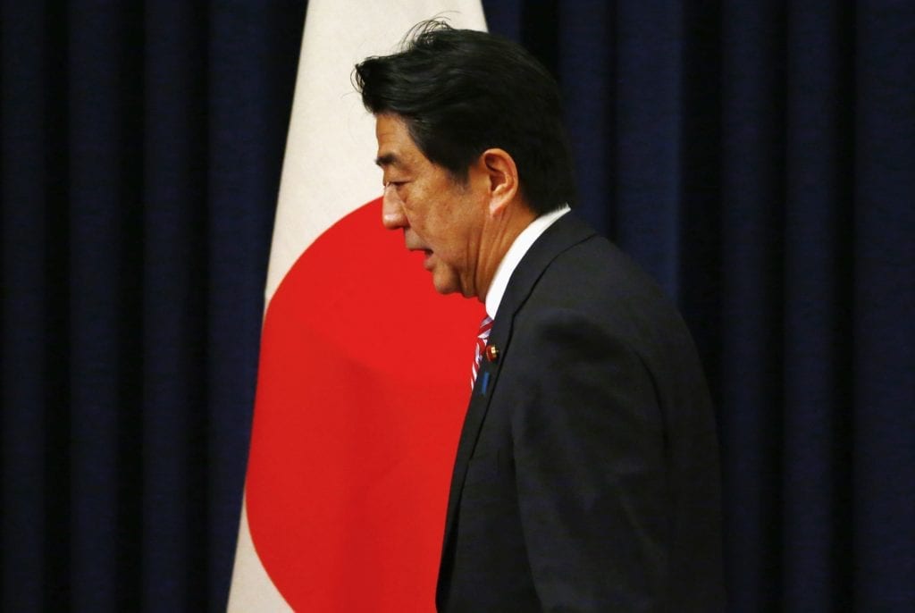 File photo of Japan’s Prime Minister Abe passing by a Japanese flag after a news conference in Beijing